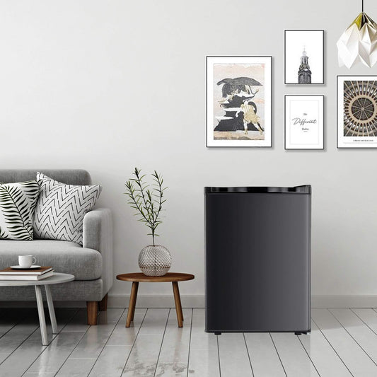 Black refrigerator in a living room with gray sofa, small table, and wall art.