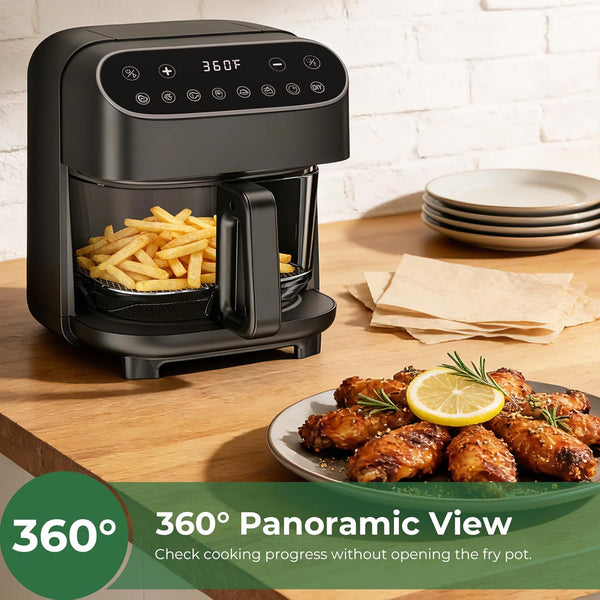 Black air fryer with fries and roasted chicken on a wooden table.