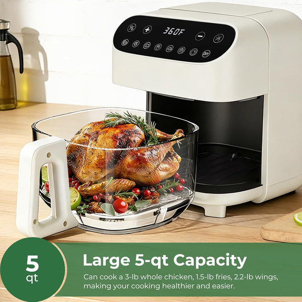 White air fryer with a cooked chicken inside on a wooden countertop.