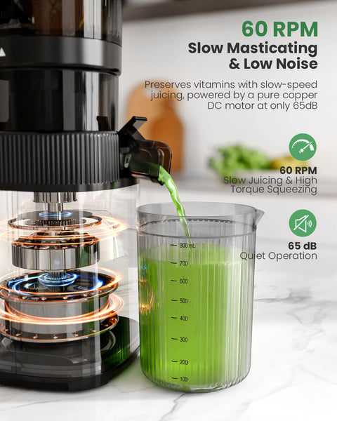 Juicer with green juice being extracted into a measuring cup on a white countertop.