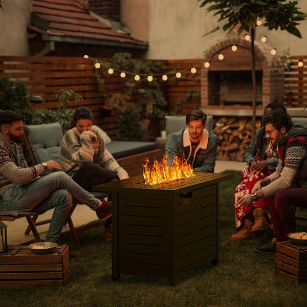 Group of people sitting around a fire pit in a backyard setting with string lights and plants.