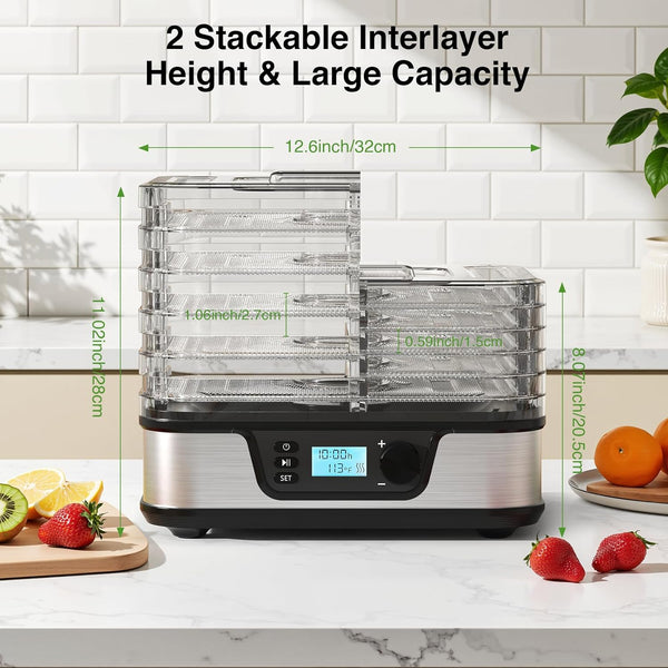 Stackable food dehydrator with digital display on a kitchen counter, surrounded by fruits and vegetables.