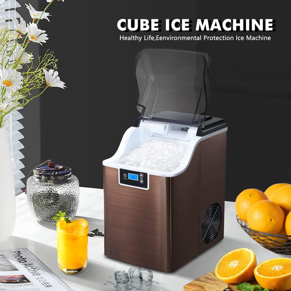 Cube ice machine with oranges and a drink on a table
