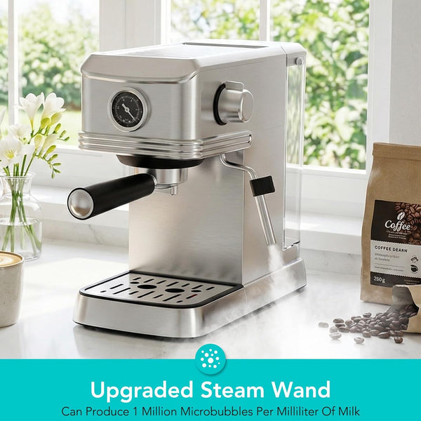 Stainless steel espresso machine on a white surface with coffee beans and a window in the background